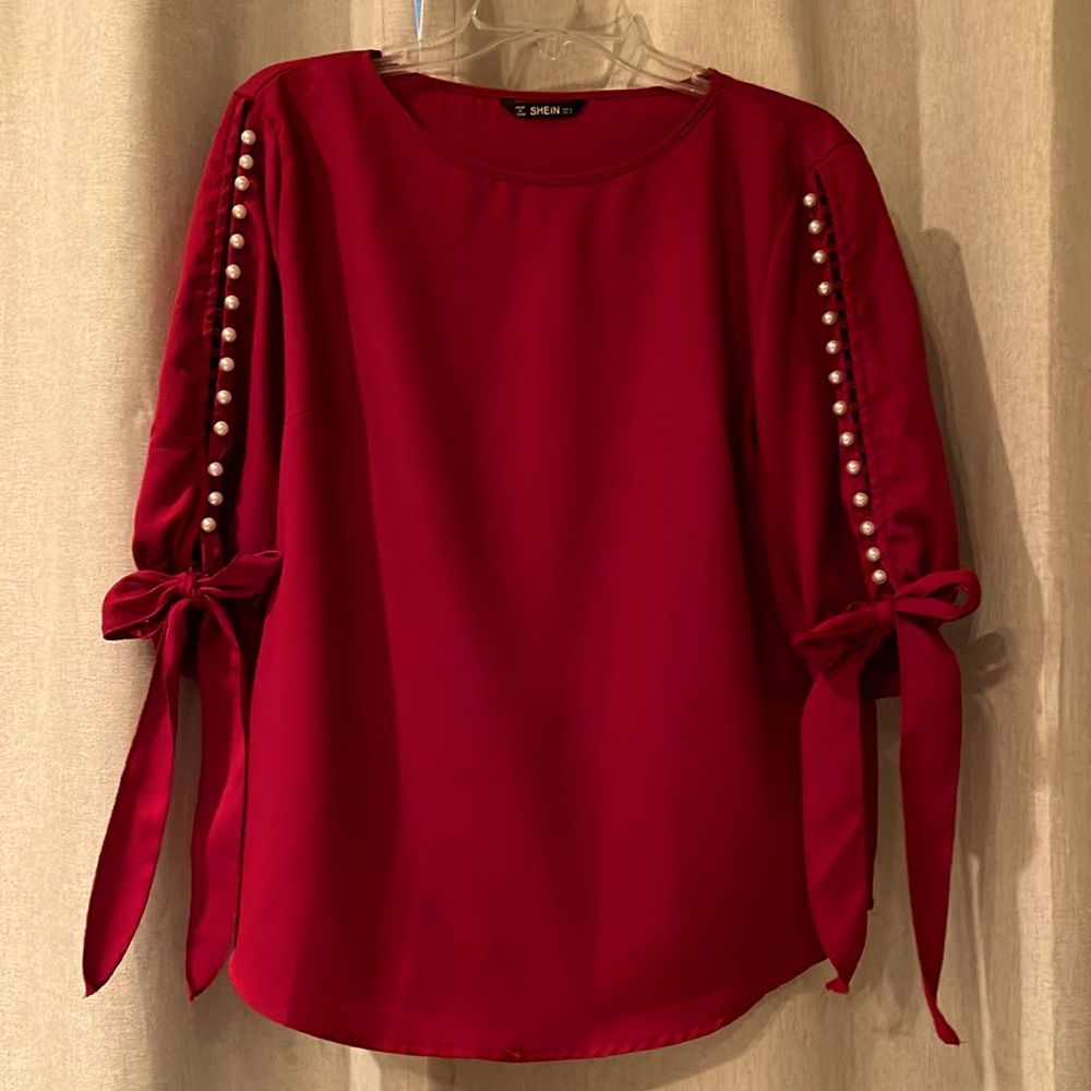 Beautiful maroon blouse with peal button sleeves.